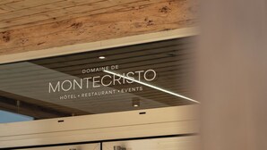 A modern building with a wooden ceiling and a sign that reads "Domaine de Montecristo Hotel, Restaurant, Events." - Logis Hôtel-Restaurant Domaine de Montecristo et Gîte l'Évasion Dantès (Bourguignons)