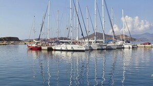 A marina with multiple sailboats docked in calm waters. - Family villa for four with one bathroom, sea view, communal pool, breakfast (Naxos island)