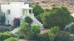 A white building with a staircase, surrounded by greenery and rocks. - Family villa for four with one bathroom, sea view, communal pool, breakfast (Naxos island)