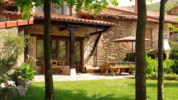A stone house with a patio, outdoor seating, and a pergola. - THE CORNER OF BESAYA. A mountain house in the Saja-Besaya reserve (Villasuso de Cieza)