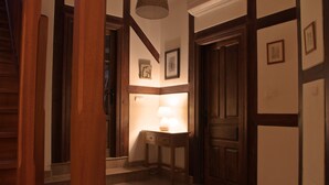 A hallway with wooden doors, a small table with a lamp, and framed pictures on the walls. - THE CORNER OF BESAYA. A mountain house in the Saja-Besaya reserve (Villasuso de Cieza)