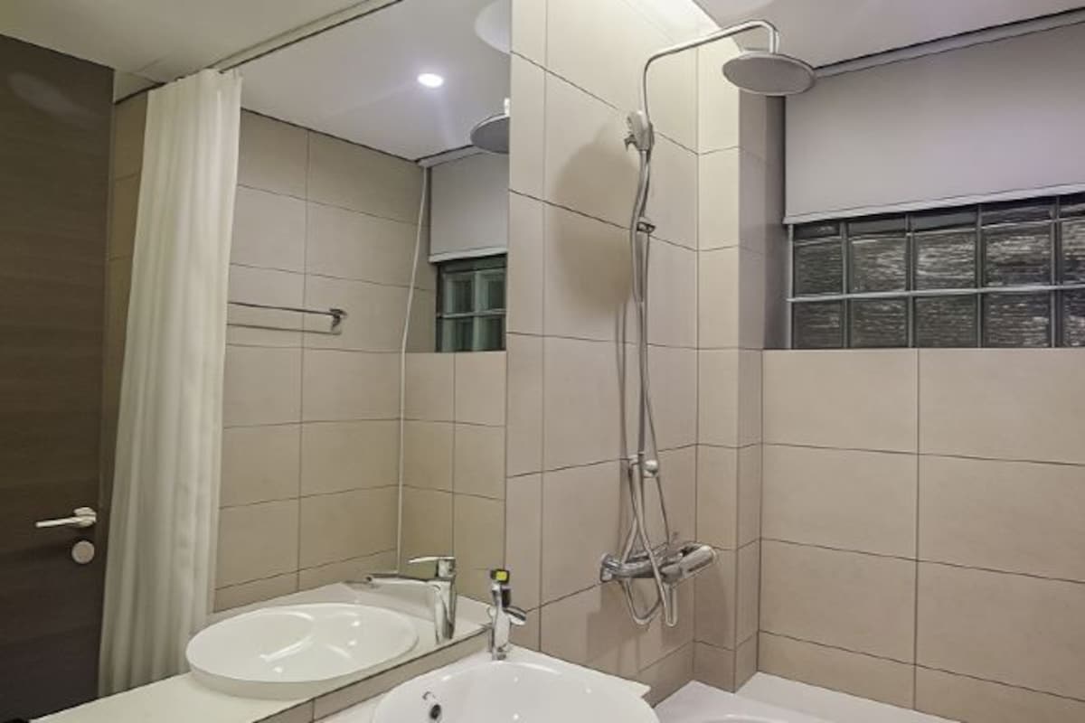 Un baño moderno con lavamanos doble, ducha y ventana con persianas.