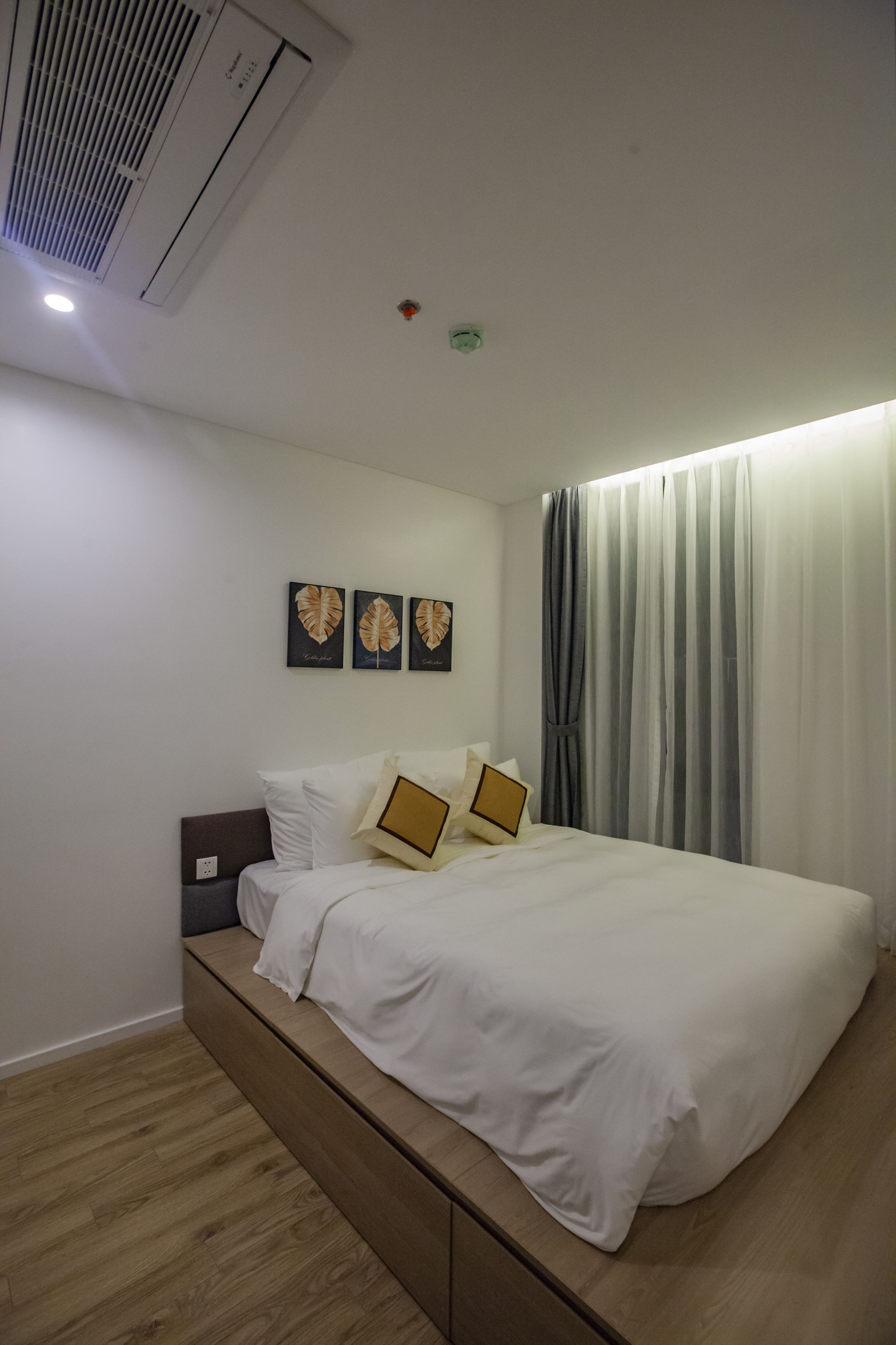 Un dormitorio moderno con cama, cabecera y un banco empotrado.