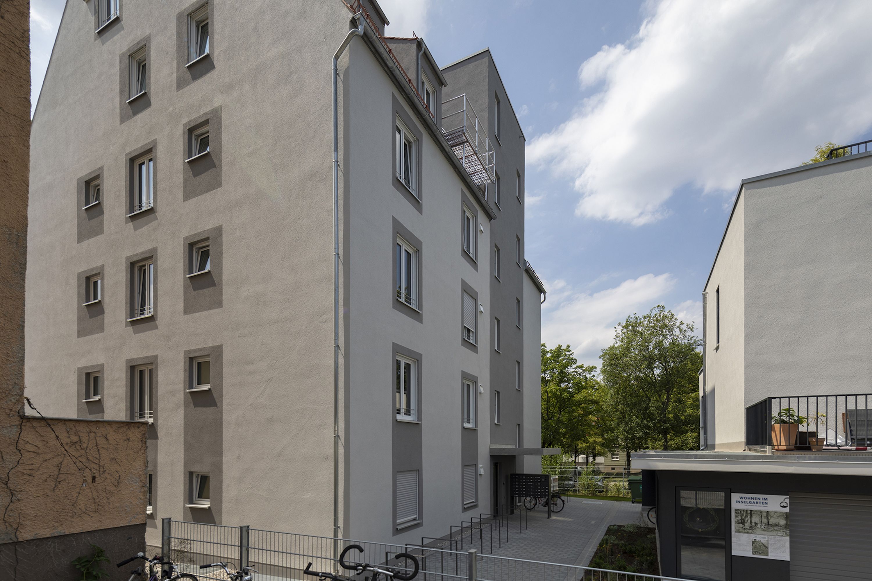 Een gebouw met meerdere verdiepingen, een platte gevel, diverse ramen en een zichtbaar balkon.