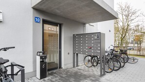A building entrance with a bike rack, a mailbox, and a door labeled 'FIZ'. - Limehome Augsburg (Augsburg)