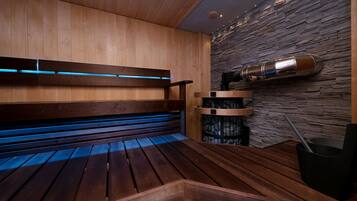 A sauna with wooden benches and a stone wall.