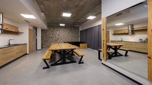 Una cocina moderna con una pared de acento de piedra, armarios de madera y una amplia mesa de comedor con bancos.
