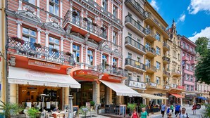 Un hotel con restaurante, tienda de antigüedades y zona de estar al aire libre con plantas en macetas.