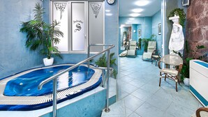 Un área de spa con un jacuzzi, una recepción y una zona de estar con sillones.