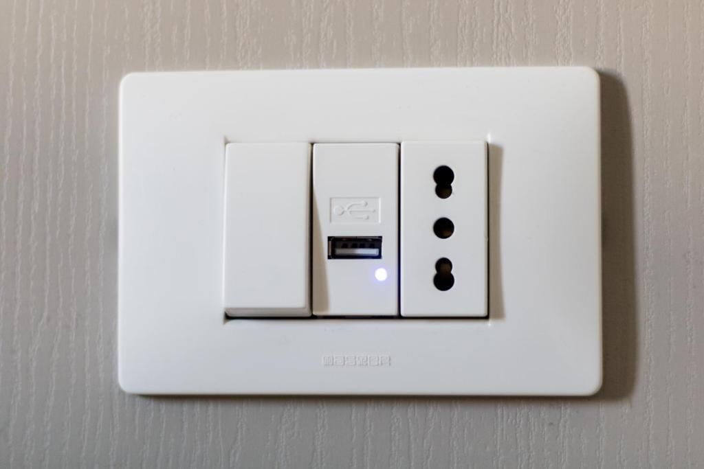 A white electrical switch with a USB port and two additional sockets.