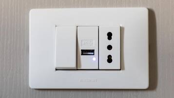 A white electrical switch with a USB port and two additional sockets.