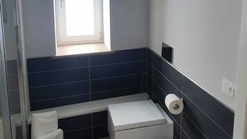A modern bathroom with a toilet, bidet, and sink.