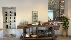 Uma cozinha com garrafas de vinho, copos e uma mesa de madeira com diversos alimentos.