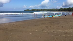 A beach with boats, people, and a clear sky. - Lagoona Beach Bungalows (Cijulang)