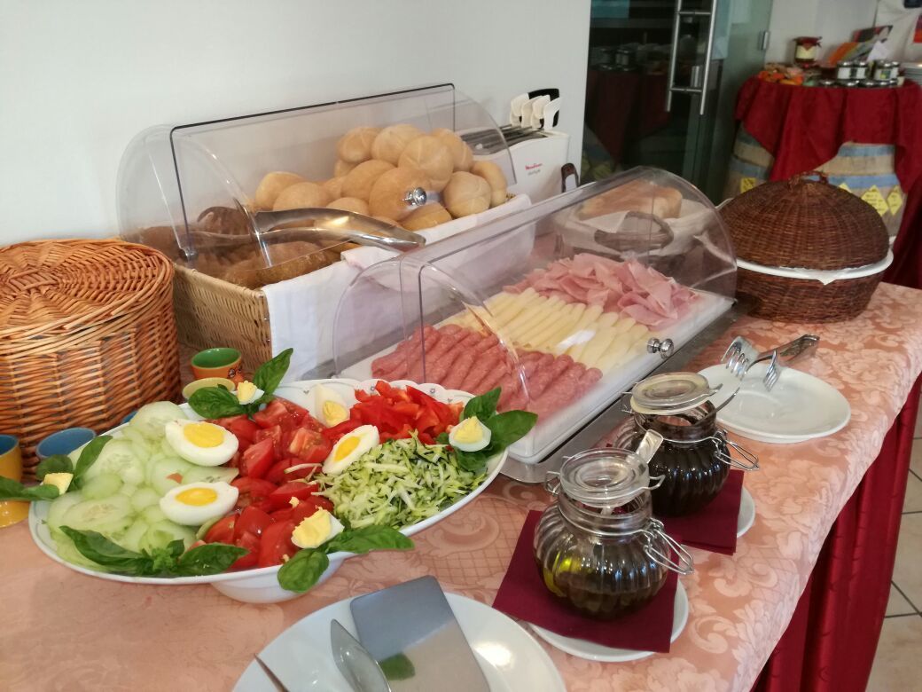 Ein reichhaltiges Buffet mit verschiedenen Speisen, darunter Brot, Fleisch, Eier und Salate.