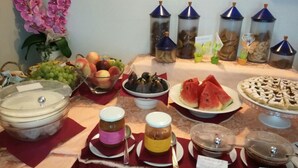 Un tavolo del buffet con diversi cibi, tra cui frutta, dolci e salse.