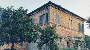 Un bâtiment en briques de deux étages, avec un chemin de pierre menant à l’entrée.