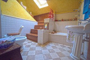 Un baño con piso a cuadros, un inodoro, un lavamanos, una bañera y una ducha.
