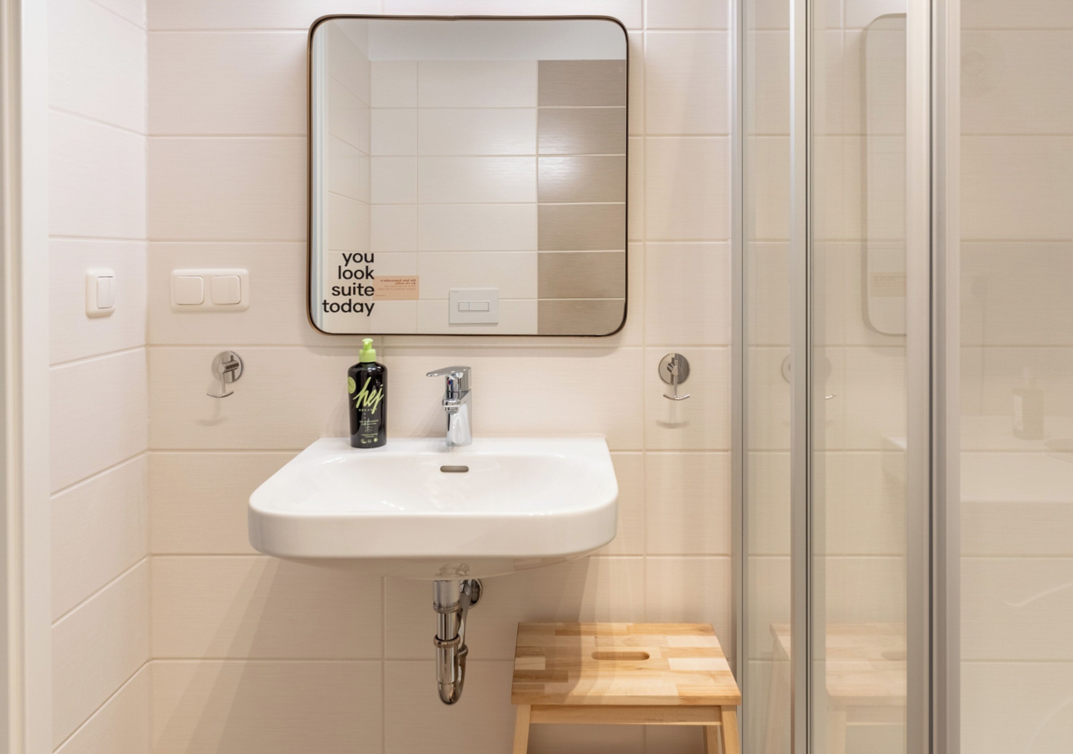 A bathroom with a white sink, a mirror, and a shower.