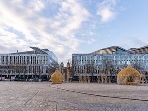 A spacious plaza with cobblestone paving, modern buildings, and decorative golden spheres. - Limehome Magdeburg Hasselbachplatz (Magdeburg)