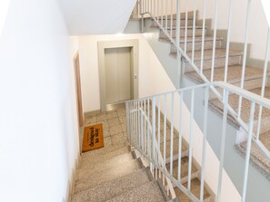 A staircase with white railings and granite steps. - Limehome Magdeburg Hasselbachplatz (Magdeburg)