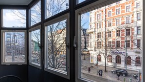 A room with large windows offering views of a historic building and a street scene.