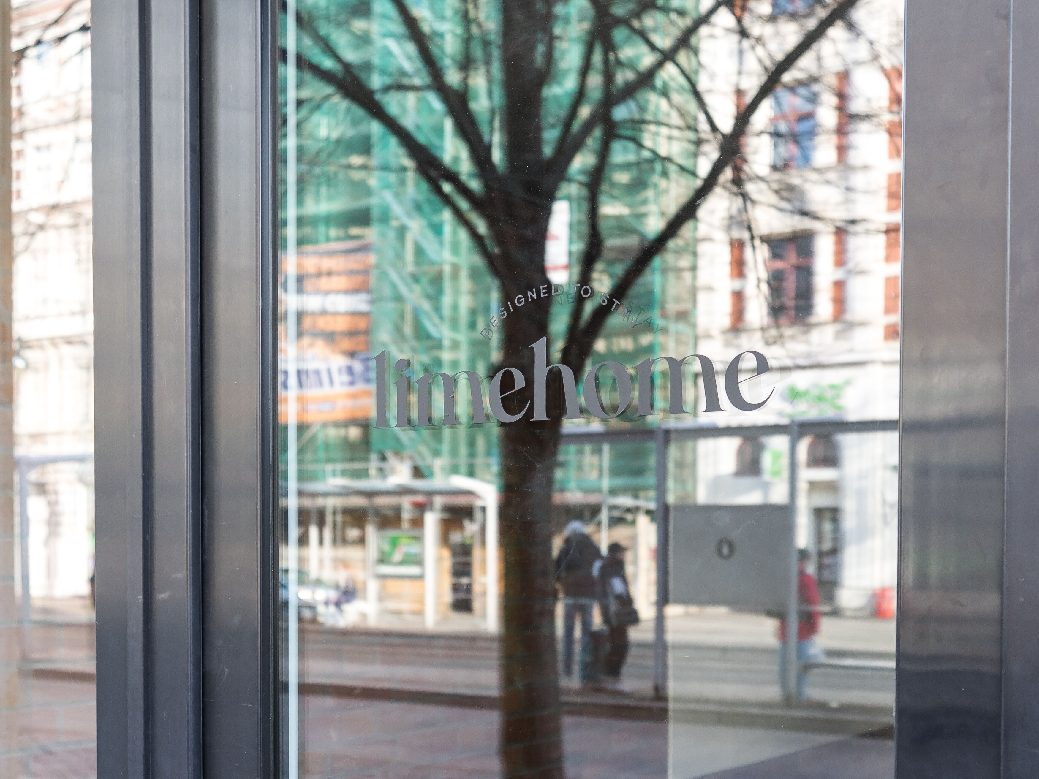 A window with the text "timehome" and a view of a tree and buildings outside.