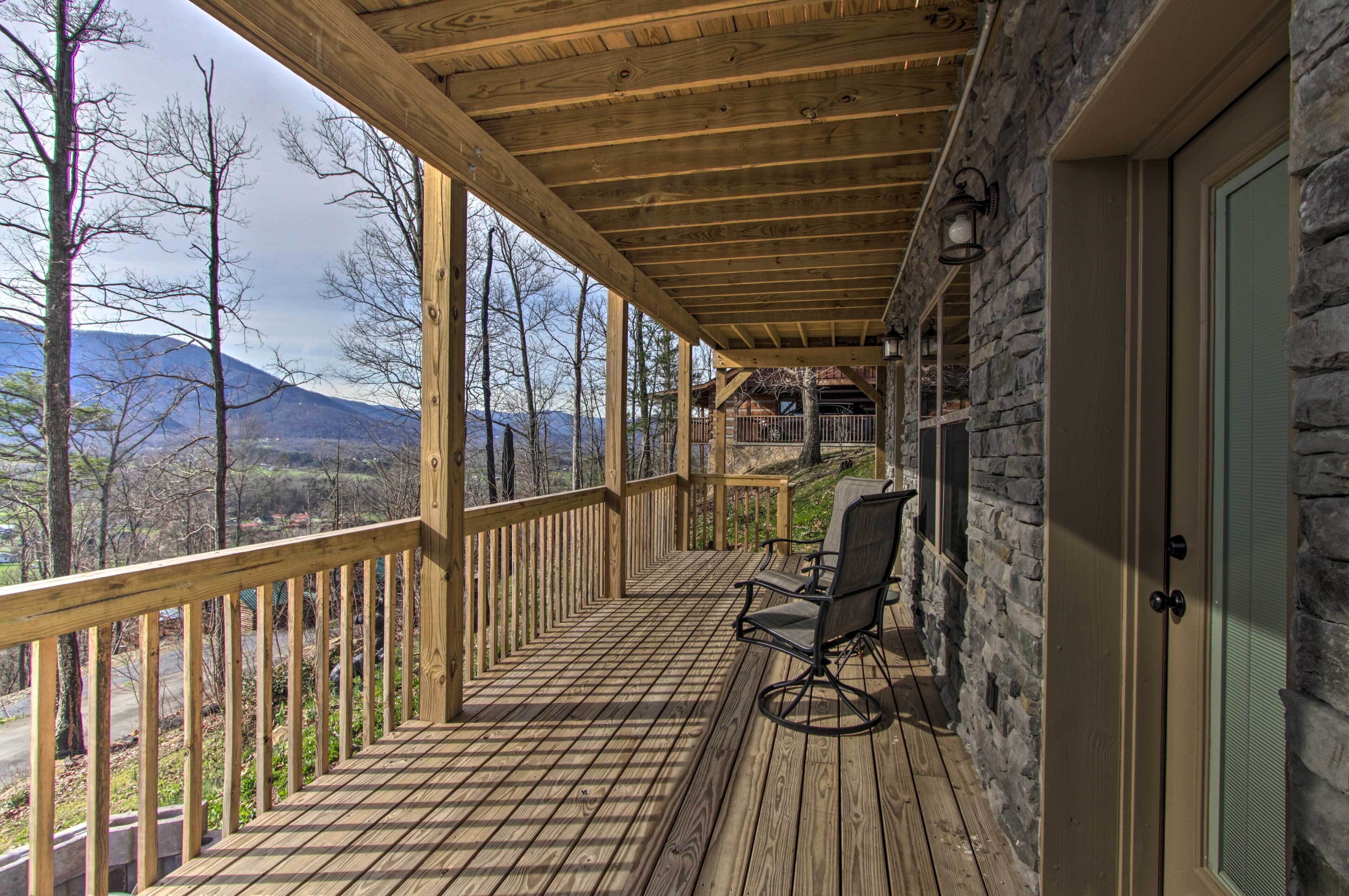 A wooden deck with a stone wall and a chair.