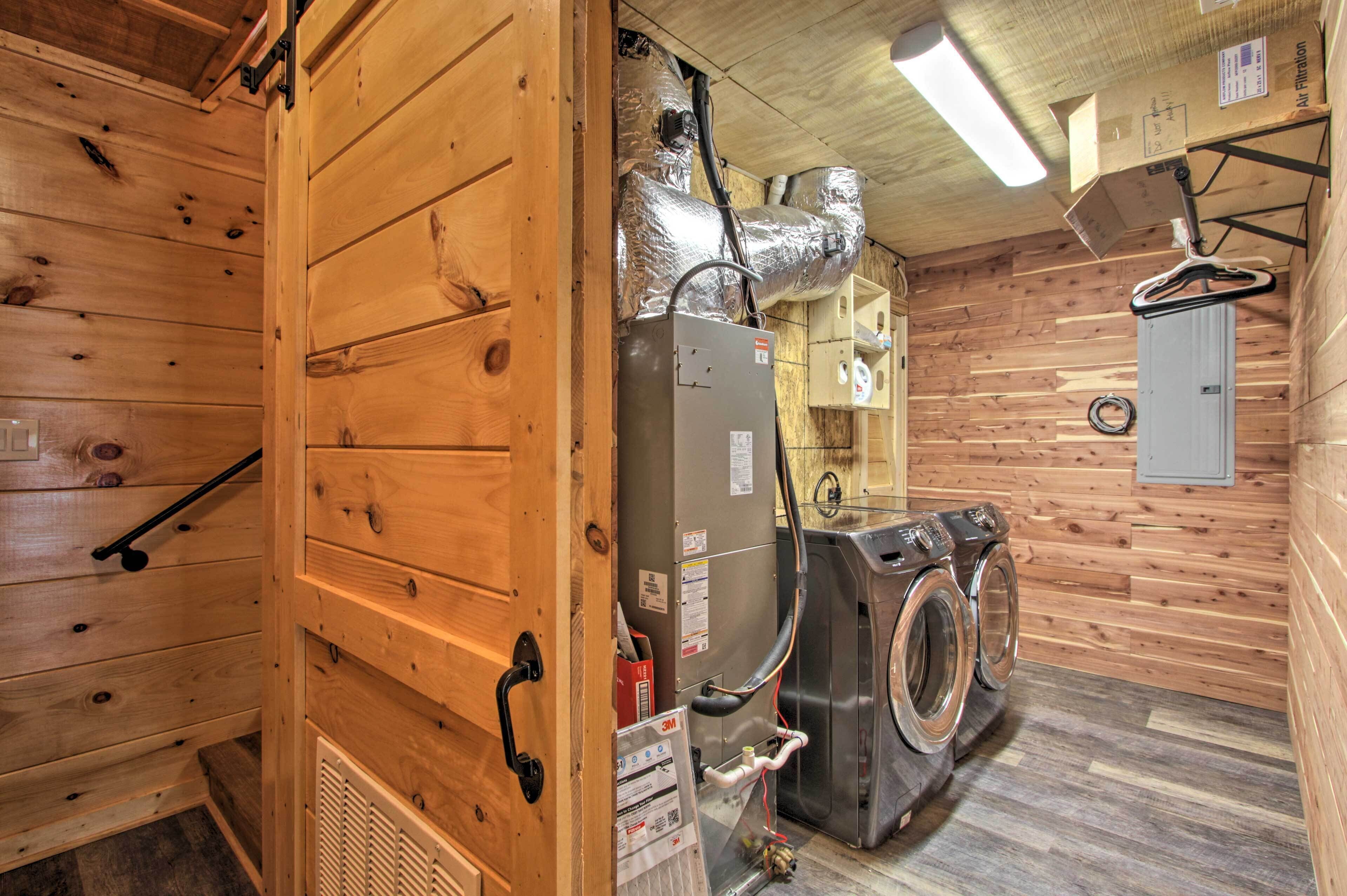 A laundry room with a washing machine, a dryer, and a utility room with a water heater and electrical panel.