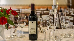 Tavola imbandita con bicchieri da vino, una bottiglia e una candela.