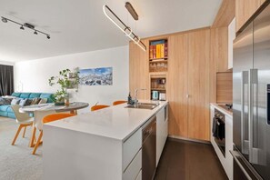 Eine moderne Küche mit einer zentralen Kochinsel, Holzschränken und Edelstahlgeräten.