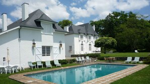 A large white house with a swimming pool, surrounded by greenery and outdoor furniture. - Clos Mirabel Manor B&B (Jurancon)