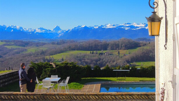 A terrace with a table and chairs overlooking a mountainous landscape. - Clos Mirabel Manor B&B (Jurancon)