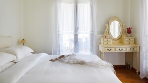 A bedroom with a bed, a dresser with a mirror, and a lamp. - Two bedroom villa with two bathrooms, sea view, communal pool, breakfast (Naxos)