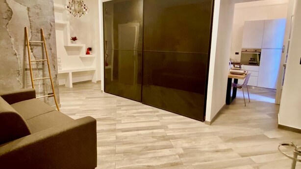 Una sala de estar moderna con un sofá, una mesa de centro y un comedor con una mesa y sillas.