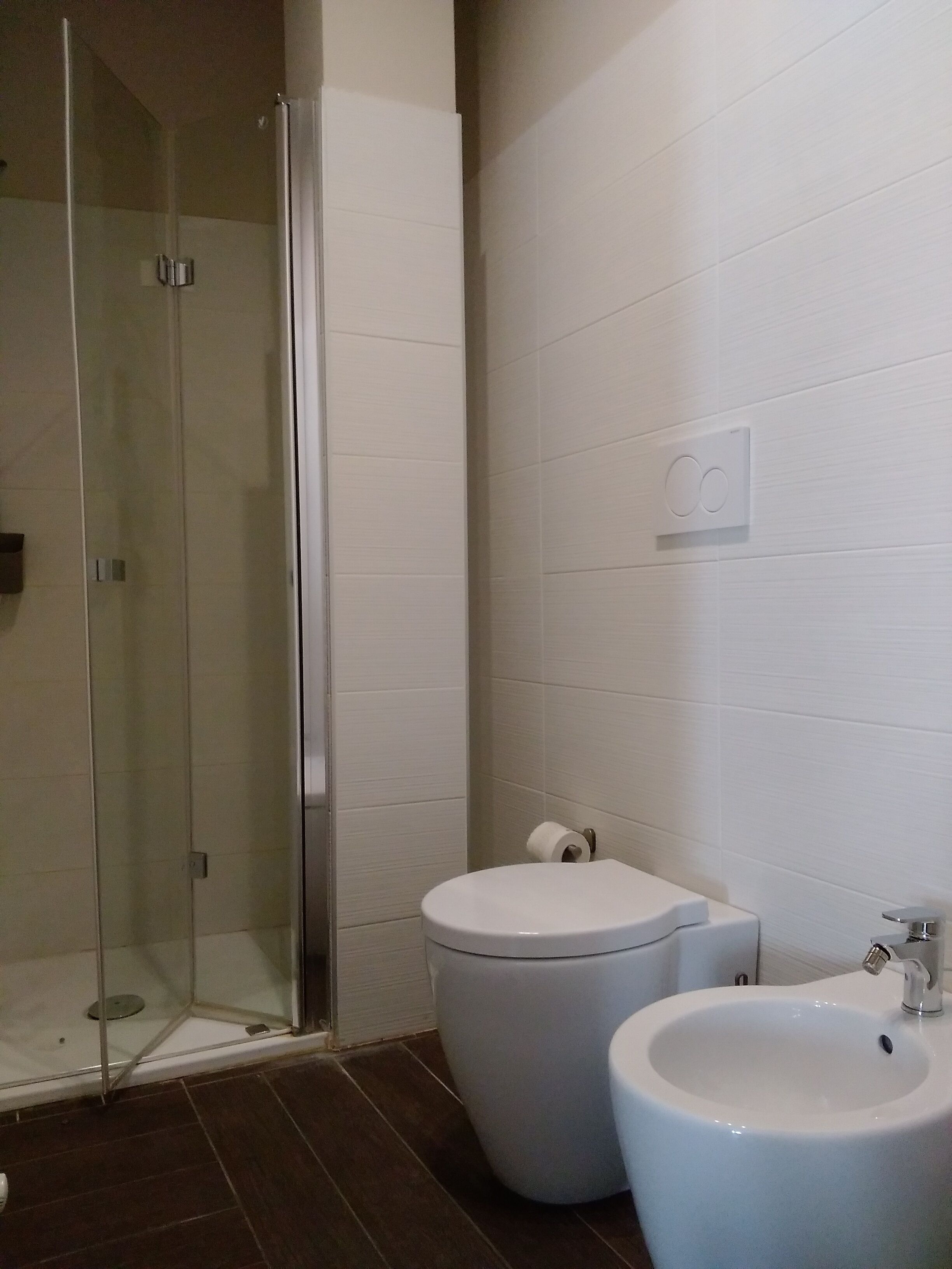 Une salle de bain moderne avec une douche à parois de verre, des toilettes et un bidet.