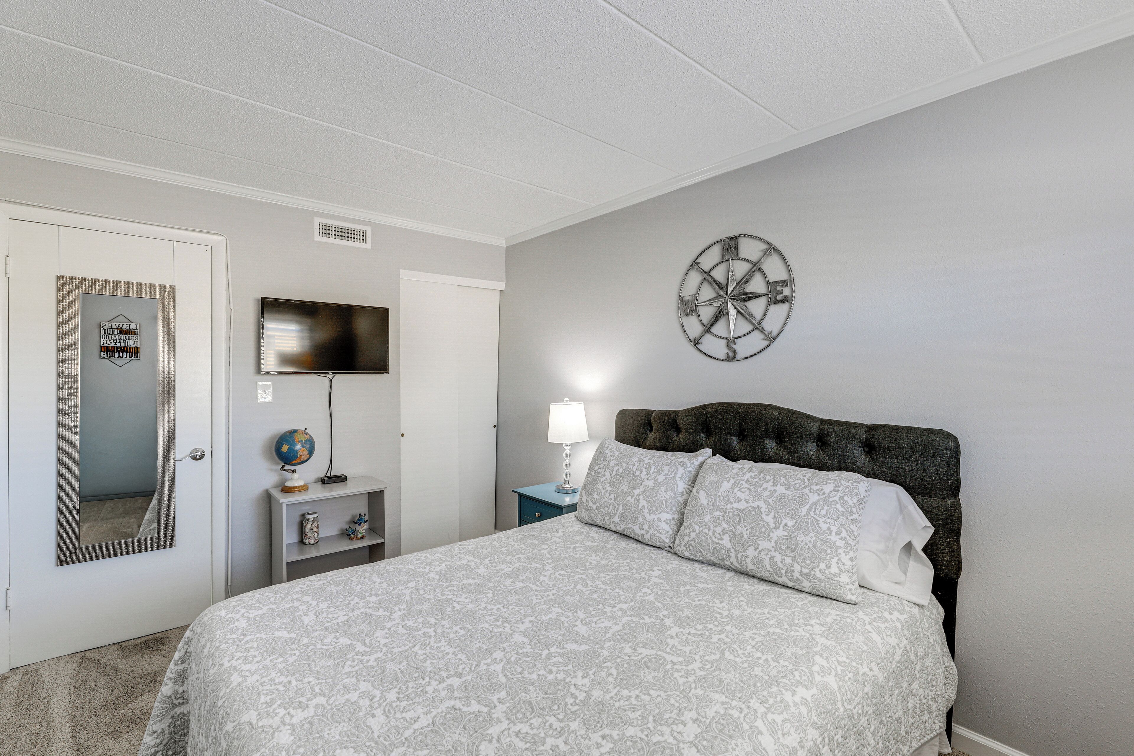 Une chambre à coucher avec un lit, une horloge murale, un globe terrestre et un téléviseur.