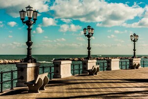 Une promenade en bord de mer, agrémentée de lampadaires et de bancs.