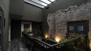 A modern interior with a stone wall, a staircase, and a skylight.