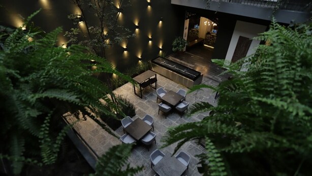 An outdoor patio area with seating arrangements and a water feature.
