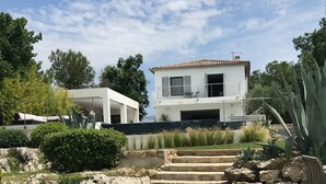 Una casa moderna con una escalera de piedra que lleva a un porche cubierto.