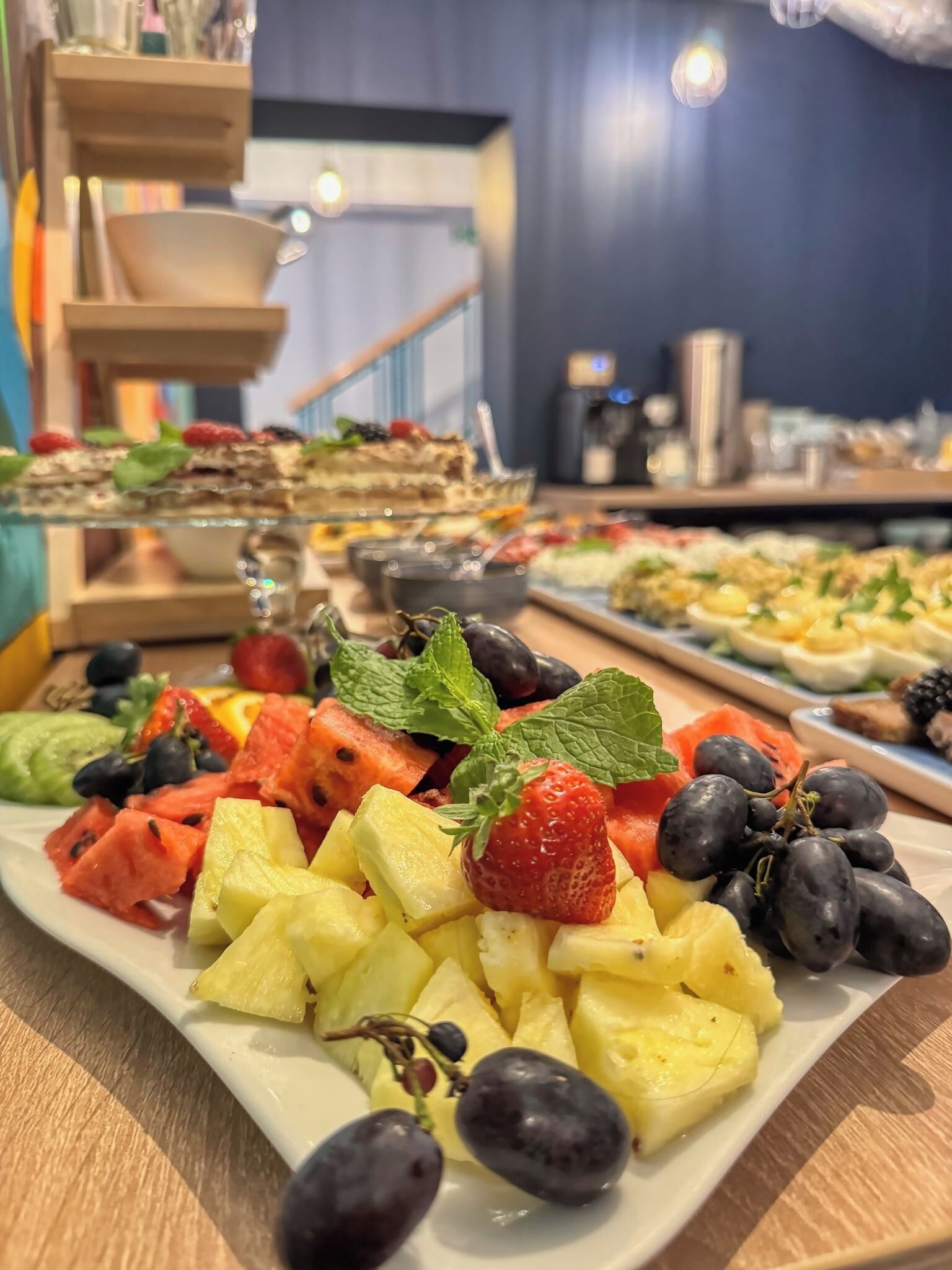 A buffet with a variety of fruits and desserts.