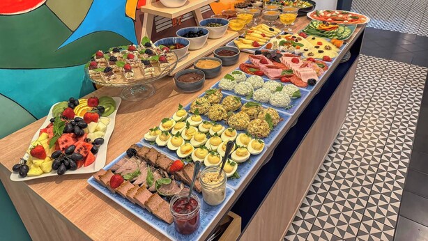 Un bufé con diferentes opciones de comida, como frutas, quesos y embutidos.