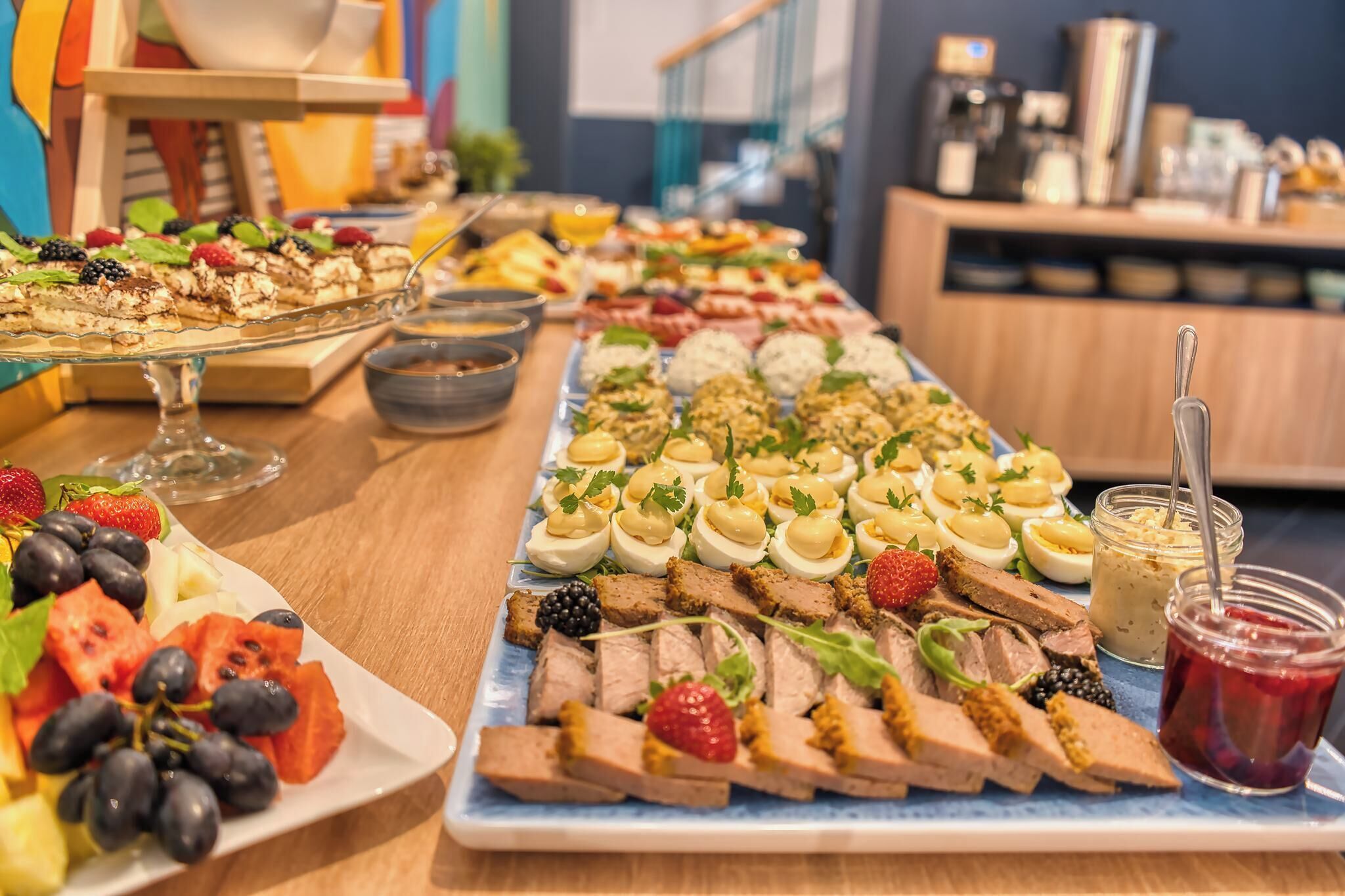 A buffet with various food items including fruits, meats, and desserts.