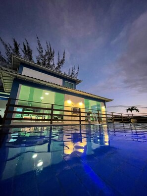 Um edifício moderno com uma piscina que reflete o céu.