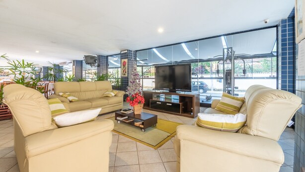 A modern living room with a beige sofa set, a coffee table, and a TV on a wooden stand.