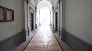 A corridor with tiled flooring, white walls, and classical architectural columns. - Elegant Apartament Copernicus (Warsaw)