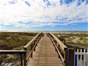 A wooden boardwalk leading to a beach with a clear sky. - 3bdrm/3bath- BEACHFRONT AND 5 steps to TWO POOLS - sleeps 8! (Dauphin Island)