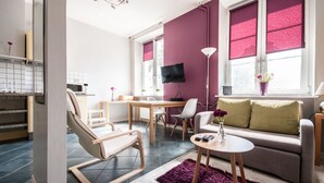 Un salon moderne comprenant un canapé, une table basse, un téléviseur et un coin repas.