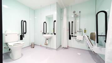 A modern bathroom with a toilet, sink, and shower area.